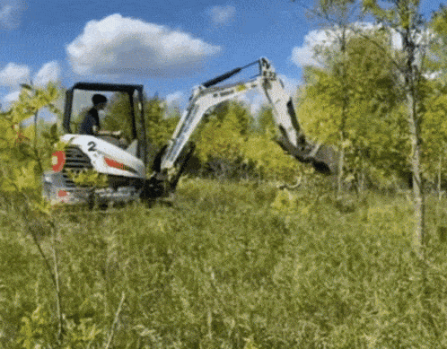 a man is driving a bobcat in a field
