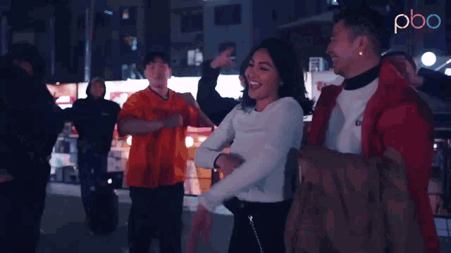 a group of people are dancing in front of a sign that says pbo on it