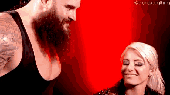 a man with a beard and a woman with blonde hair are standing next to each other and smiling .