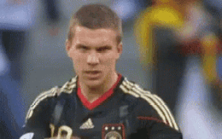 a soccer player with the number 10 on his jersey looks at the camera