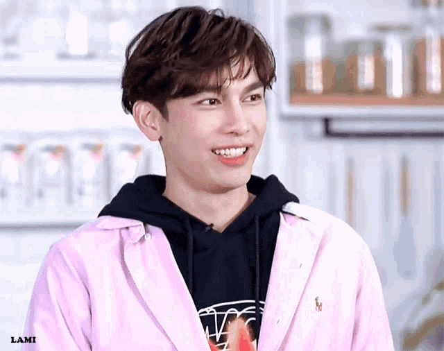 a young man is wearing a pink jacket and a black hoodie