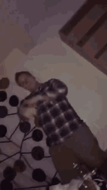 a man in a plaid shirt is dancing with a mickey mouse headband on .