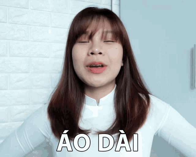 a woman in a white shirt says ao dai in white letters