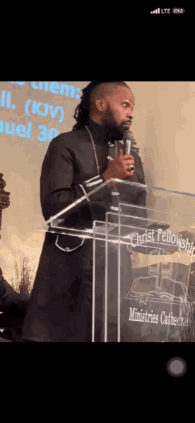 a man stands behind a clear podium that says christ fellowship ministries