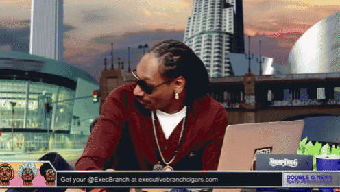 snoop dogg is sitting in front of a laptop with a double g news advertisement behind him