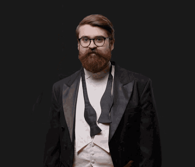 a man in a tuxedo and bow tie is making an ok sign with his hands