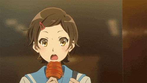 a girl with a red clip in her hair is eating a piece of food