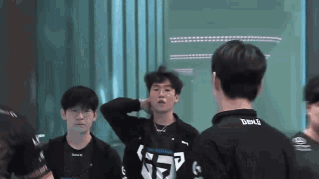 a group of young men are standing in a room and one of them is wearing a shirt that says benj