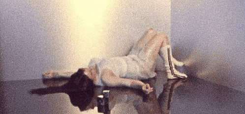a woman in a white dress is laying on the floor in a room