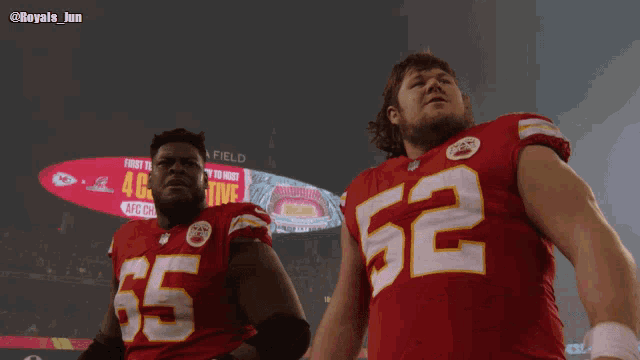 two football players standing in front of a sign that says field