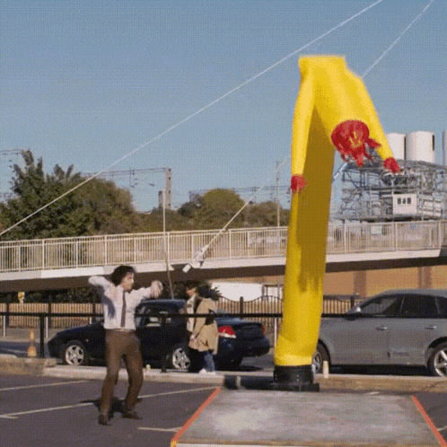 a man is standing in front of a large yellow object that looks like a mcdonald 's balloon