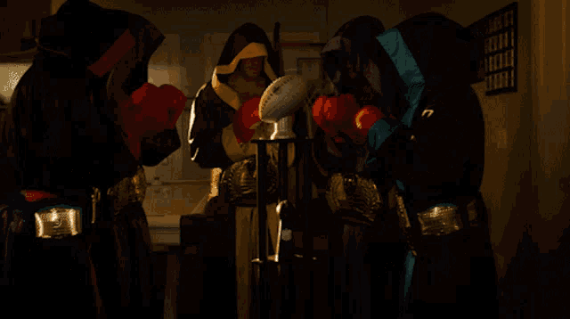 a man wearing boxing gloves is holding a football that says league on it