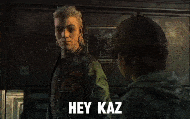 a man in a varsity jacket talks to another man in a baseball cap with the words hey kaz on the bottom