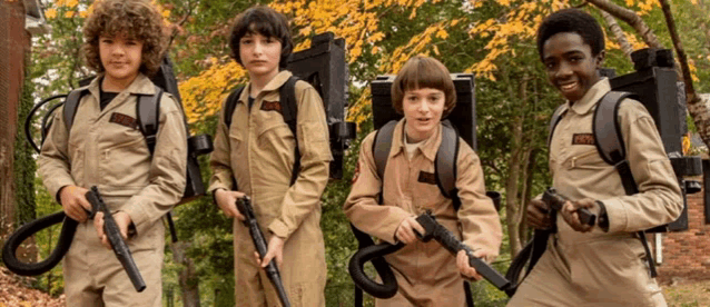 a group of young boys dressed as ghostbusters are standing next to each other holding guns