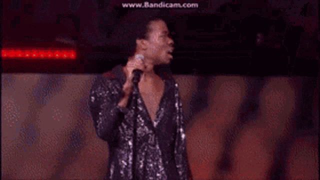 a man singing into a microphone with the website www.bandicam.com visible in the background