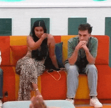 a man and a woman are sitting on a couch in a living room .