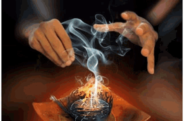 a person is holding a candle with smoke coming out of it .