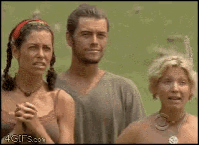 a man and two women are standing next to each other with a 4gifs.com logo in the corner .
