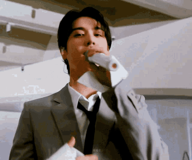 a man in a suit and tie is holding a microphone .