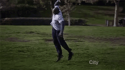a man wearing a nypd shirt is standing in a field .