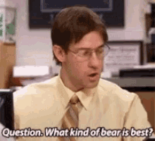 a man in a yellow shirt and tie is sitting in front of a computer .