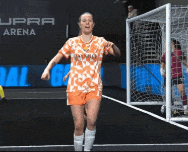 a female soccer player wearing an orange and white jersey that says dynamo on it