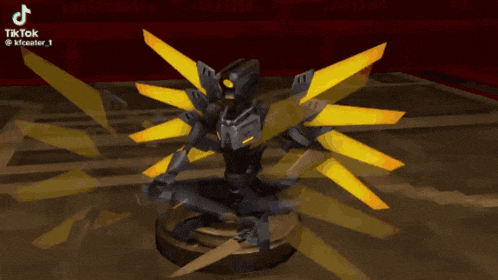 a statue of a robot with yellow wings is sitting on a table ..