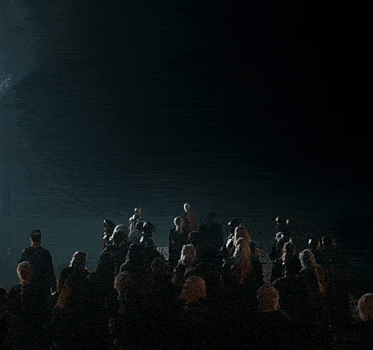 a group of people standing in a dark room looking up at a dragon