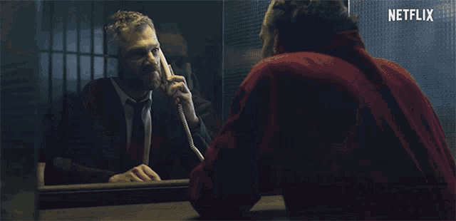 a netflix ad shows a man sitting at a table with another man