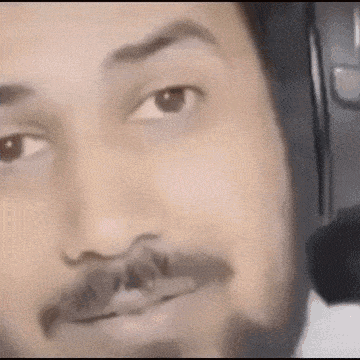 a close up of a man with a beard wearing headphones .