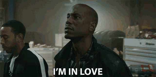 two men are standing next to each other and one of them is saying i 'm in love .