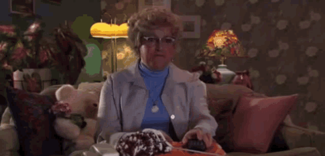 a woman is sitting on a couch in a living room with her arms outstretched .