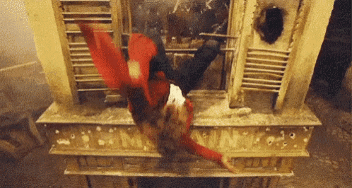 a person in a red jacket is falling down a staircase .