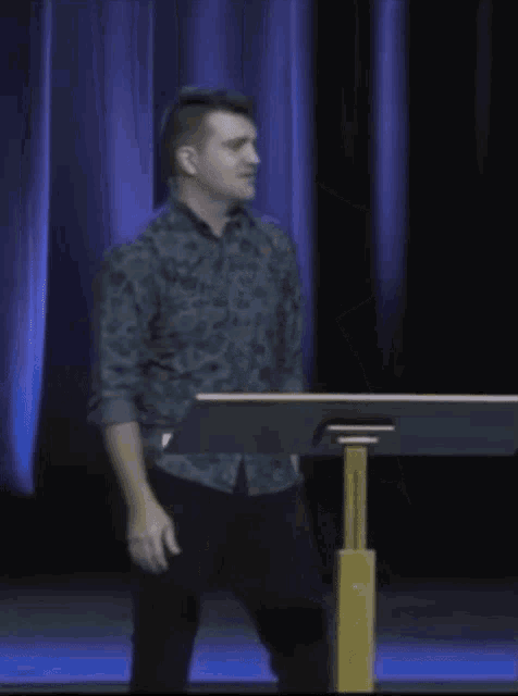 a man stands at a podium with his arms in the air