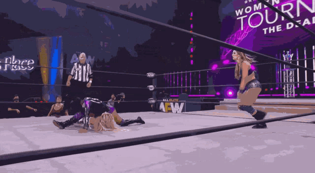 a woman is laying on the ground in a wrestling ring that says aew