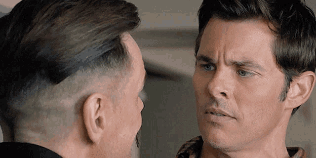two men are looking at each other in a close up of their faces .