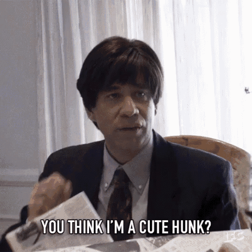 a man in a suit and tie is holding a piece of paper and says you think i 'm a cute hunk