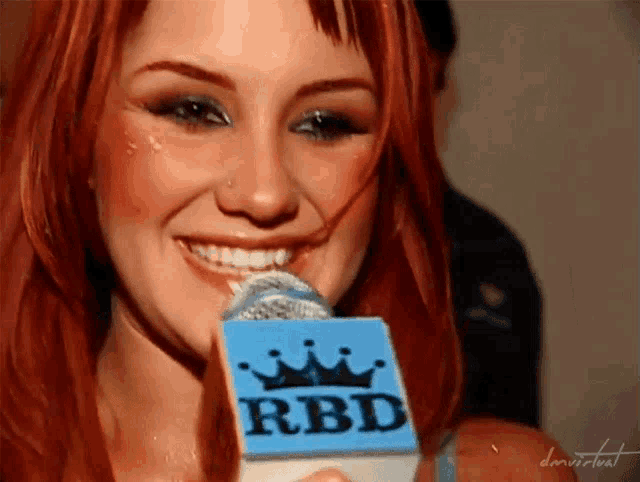 a woman holding a microphone that says rbd