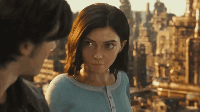 a man and a woman are looking at each other and the woman is wearing a blue shirt