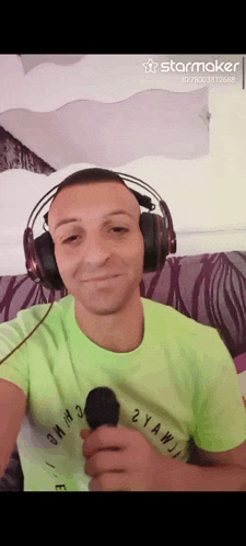 a man wearing headphones and a neon green shirt is holding a microphone in his hand