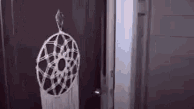 a dream catcher is hanging on a door .