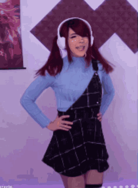 a girl wearing headphones and a blue sweater is dancing
