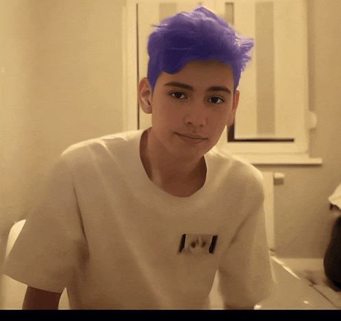 a young boy with purple hair is wearing a white shirt with the canadian flag on the back