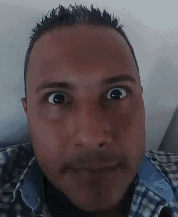 a man in a plaid shirt is making a funny face with his eyes crossed .