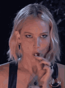 a close up of a woman smoking a cigarette with her mouth open .