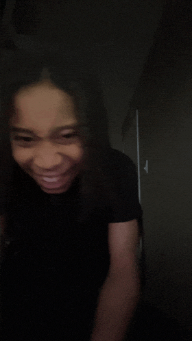a blurry picture of a woman in a black shirt smiling
