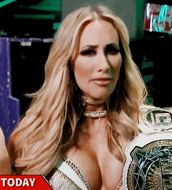 a woman in a very revealing top is holding a world heavyweight wrestling belt