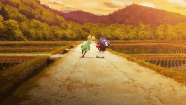 a couple of people walking down a dirt road