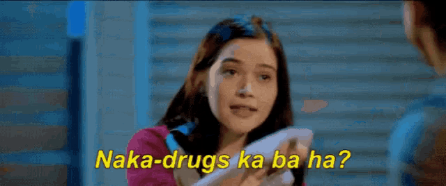 a woman holding a cell phone with the words naka-drugs ka ba ha on the bottom
