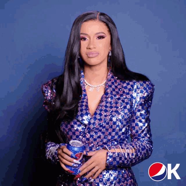 a woman holding a can of pepsi in front of a blue background